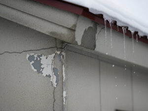ひび割れた外壁とつららが垂れた屋根